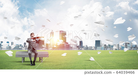 Handsome violinist in park on wooden bench play his melody 64039466