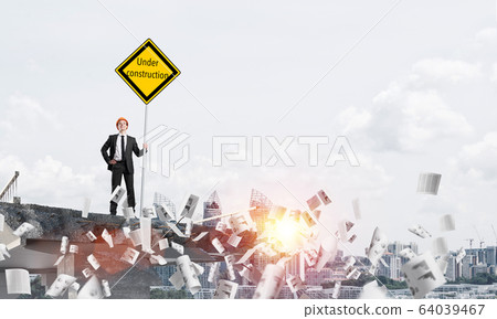 Confident engineer holding street safety sign. 64039467
