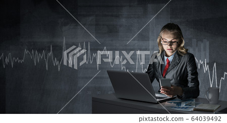Businesswoman in glasses sitting at office desk 64039492