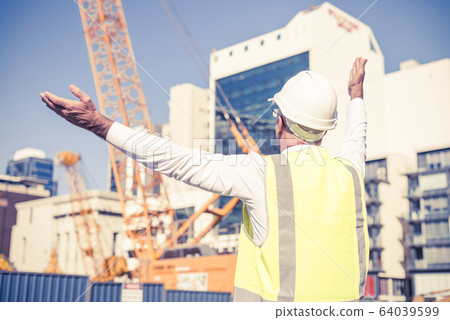 Senior foreman in glasses doing his job at building area on sunn Senior foreman in glasses doing his job at building area on sunn 64039599