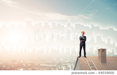 Engineer man standing on roof and looking away. Mixed media Engineer man standing on roof and looking away. Mixed media 64039600