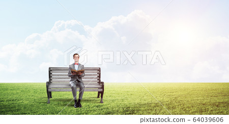 Young businessman or student studying the science in summer park Young businessman or student studying the science in summer park 64039606