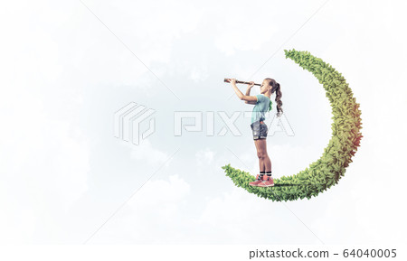 Concept of careless happy childhood with girl on green moon Concept of careless happy childhood with girl on green moon 64040005