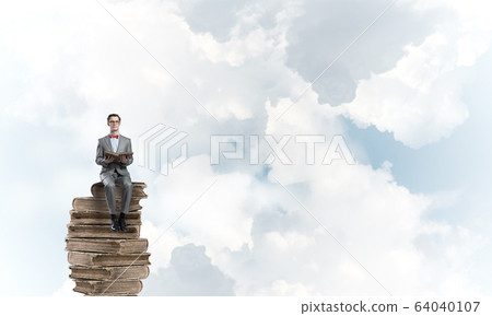 Young businessman or student floating in blue sky and studying the science Young businessman or student floating in blue sky and studying the science 64040107