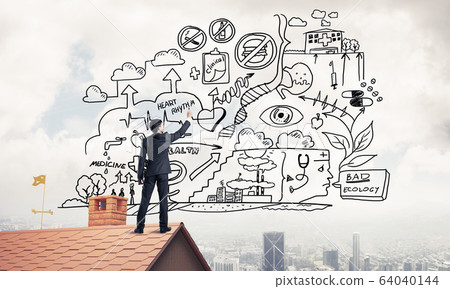 Rear view of businessman on house roof drawing his new business Rear view of businessman on house roof drawing his new business 64040144