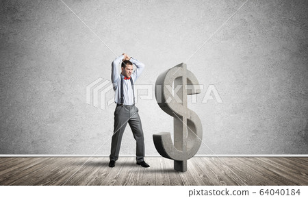 Determined banker man in empty concrete room breaking dollar figure 64040184