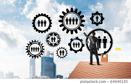 Businessman on house roof presenting teamwork and connection concept. Mixed media Businessman on house roof presenting teamwork and connection concept. Mixed media 64040185