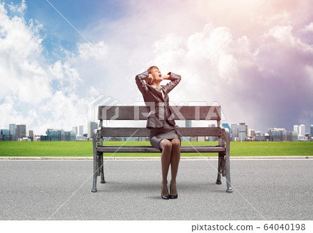 Stressful woman sitting on wooden bench Stressful woman sitting on wooden bench 64040198