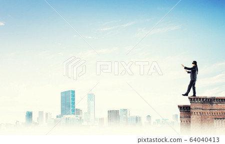 Danger and risk concept with businessman making step from edge Danger and risk concept with businessman making step from edge 64040413
