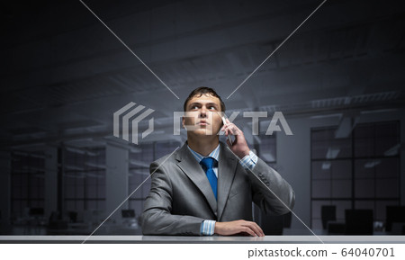 Young man talking on phone and looking upward. Young man talking on phone and looking upward. 64040701