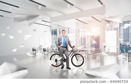 Smiling man in business suit standing with bike Smiling man in business suit standing with bike 64040720