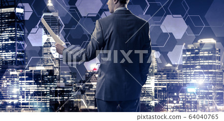 Rear view of businessman against night cityscape background and 64040765