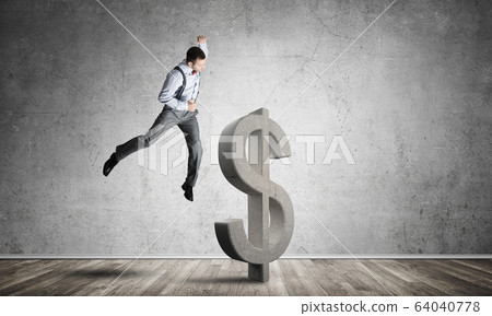 Determined banker man in empty concrete room breaking dollar figure 64040778