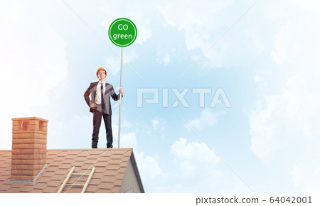 Businessman in suit on house top with ecology concept signboard. 64042001