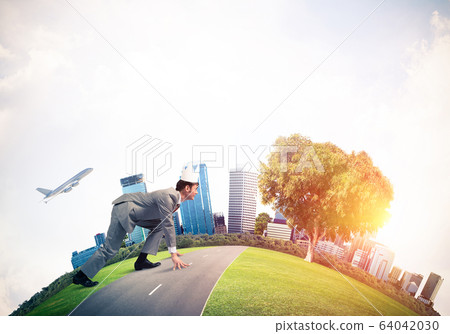 King businessman in elegant suit running on green globe with mod 64042030