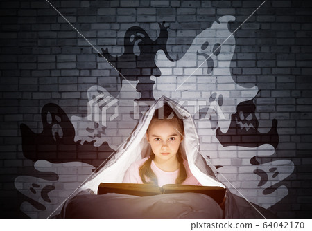 Engrossed little girl reading book in bed Engrossed little girl reading book in bed 64042170