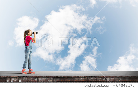 Concept of careless happy childhood with girl of school age looking in future Concept of careless happy childhood with girl of school age looking in future 64042173