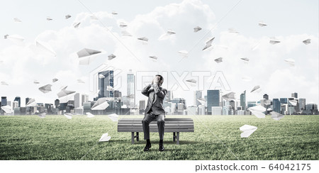Young man in summer park on bench do not want to see anything Young man in summer park on bench do not want to see anything 64042175