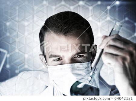 Portrait of concentrated male scientist working with reagents in laboratory Portrait of concentrated male scientist working with reagents in laboratory 64042181