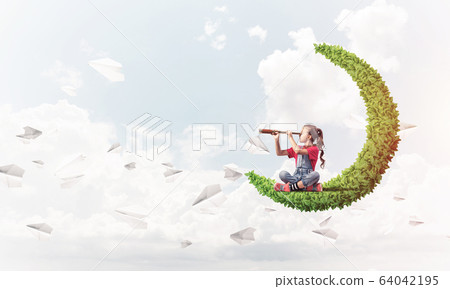 Concept of careless happy childhood with girl on green moon Concept of careless happy childhood with girl on green moon 64042195