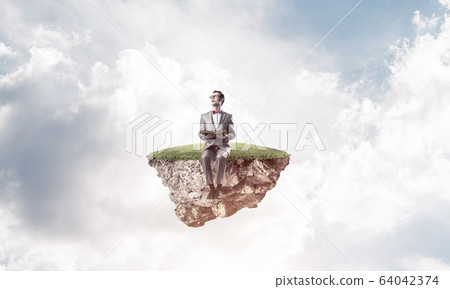 Young businessman or student floating in sky and studying the sc Young businessman or student floating in sky and studying the sc 64042374