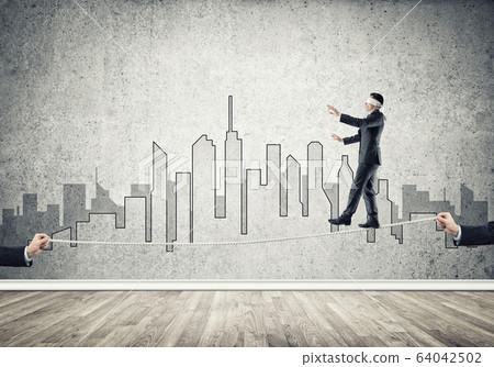 Business concept of risk support and assistance with man balancing on rope Business concept of risk support and assistance with man balancing on rope 64042502