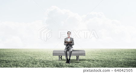 Young businessman or student studying the science in summer park Young businessman or student studying the science in summer park 64042505