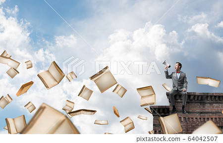 Businessman on building edge announcing something in loudspeaker Businessman on building edge announcing something in loudspeaker 64042507