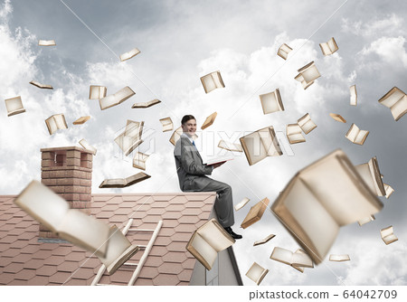 Man reading book and many of them flying in air Man reading book and many of them flying in air 64042709