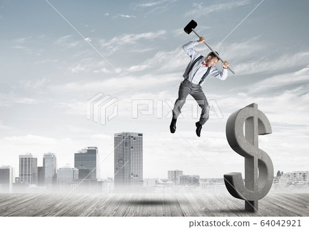 Determined banker man against modern cityscape breaking dollar concrete figure Determined banker man against modern cityscape breaking dollar concrete figure 64042921