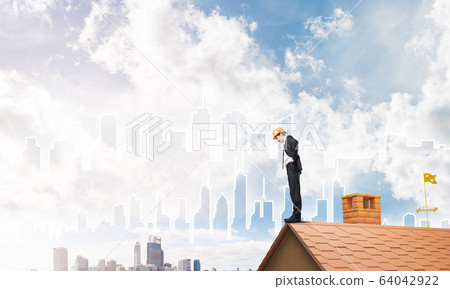 Engineer man standing on roof and looking down. Mixed media 64042922