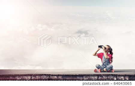 Concept of careless happy childhood with girl of school age look 64043065