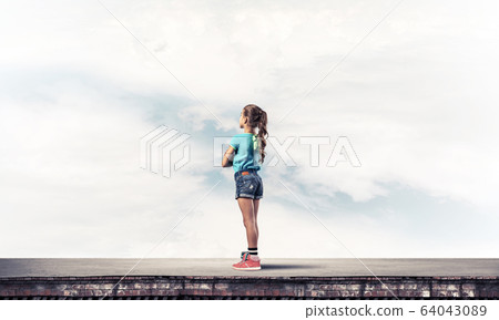 Concept of careless happy childhood with girl looking far away Concept of careless happy childhood with girl looking far away 64043089