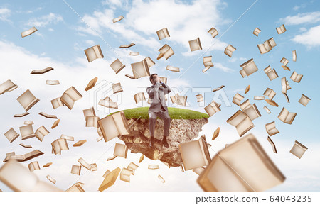 Young man do not want to see anything and books fly around Young man do not want to see anything and books fly around 64043235