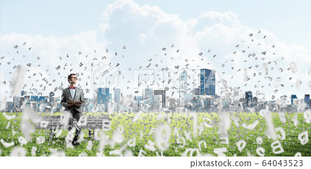 Young businessman or student studying the science and symbols fly around Young businessman or student studying the science and symbols fly around 64043523