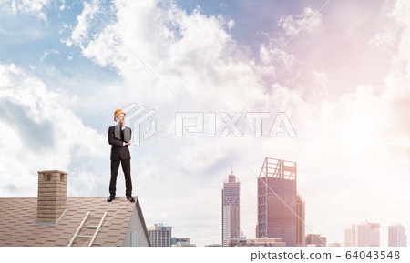 Engineer man standing on roof and looking away. Mixed media Engineer man standing on roof and looking away. Mixed media 64043548