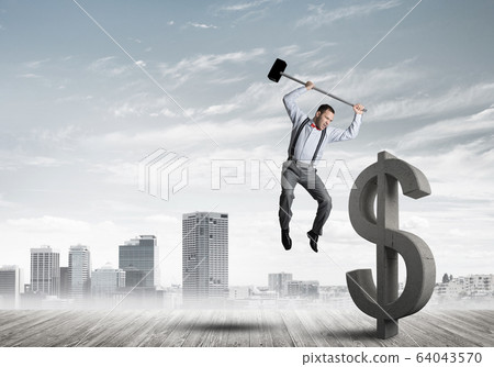 Determined banker man against modern cityscape breaking dollar concrete figure 64043570