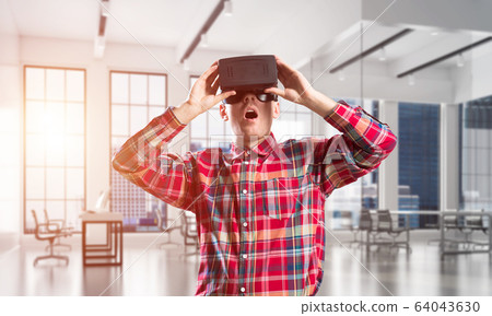 Concept of modern entertaining technologies with man wearing virtual reality mask 64043630