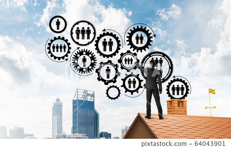 Businessman on house roof presenting teamwork and connection concept. Mixed media Businessman on house roof presenting teamwork and connection concept. Mixed media 64043901