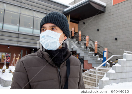 Asian tourist man wearing mask protecting from Coronavirus 64044010