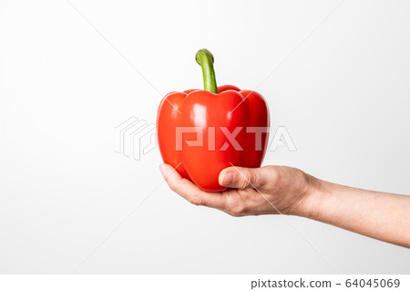 Woman holding red, sweet pepper or paprika. Health and healthy lifesyle Woman holding red, sweet pepper or paprika. Health and healthy lifesyle 64045069
