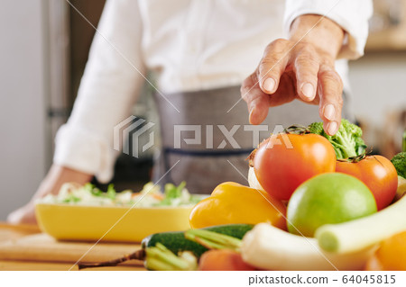 Man cooking vegetables 64045815