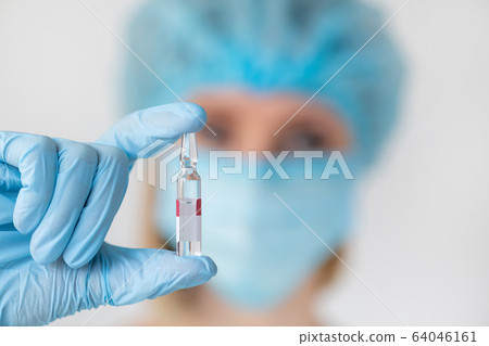 Medicine ampoule for injection in nurse hand. 64046161