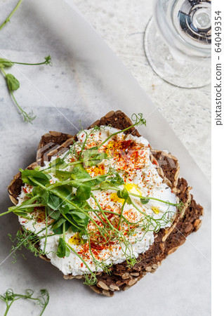 Toast with cream cheese and seedlings, top view. Toast with cream cheese and seedlings, top view. 64049354
