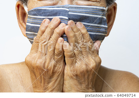 Senior woman wearing DIY handmade striped cloth face mask, Medical mask, Surgical mask, Two hands closing mouth in white, Front view, Close up shot, Prevention from covid19, Coronavirus, Healthcare Senior woman wearing DIY handmade striped cloth face mask, Medical mask, Surgical mask, Two hands closing mouth in white, Front view, Close up shot, Prevention from covid19, Coronavirus, Healthcare 64049714