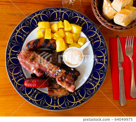 Fried meat and sausages with french fries. Spanish cuisine 64049975