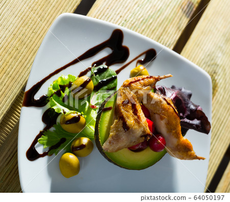 Delicious fried legs of quail with balsamic pasta, avocado and greens 64050197