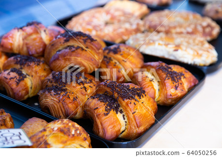Closeup of various delicious sweet croissants presented on bakery showcase Closeup of various delicious sweet croissants presented on bakery showcase 64050256