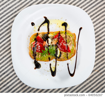 Top view of sandwich with guacamole, canned tuna, feta, vegetables on white plate Top view of sandwich with guacamole, canned tuna, feta, vegetables on white plate 64050287