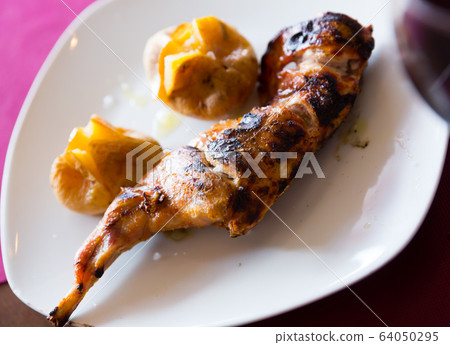 Delicious baked quarter of rabbit with pototoes at plate 64050295